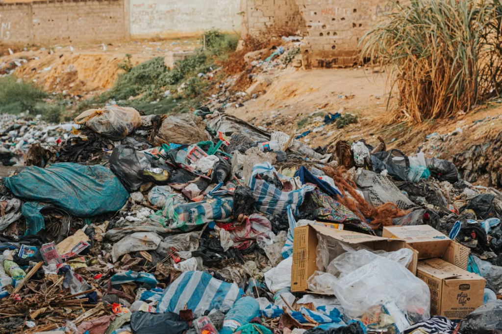 Pile of mixed waste at a sprawling urban landfill, highlighting environmental pollution